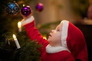 A child admiring the ornaments on a Christmas tree