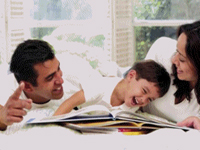 Mother and Father and son - laughing and enjoying reading.